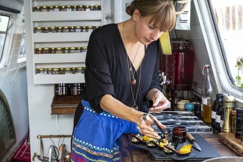 Jemma Foster plating a dish in the galley