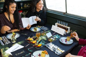 Guests laughing around the dining table aboard the boat