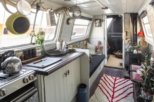 The galley with salvaged fittings, hanging pans, antlers and a wood stove